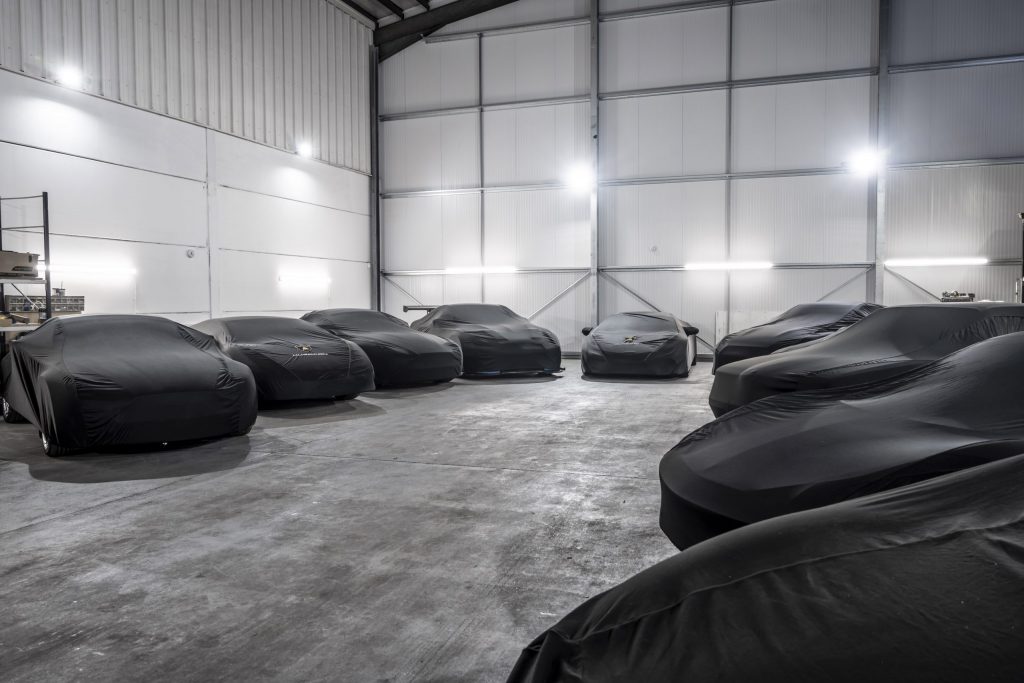 Garage containing 9 cars with black protective coverings