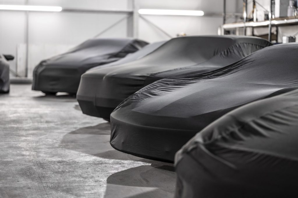 Garage containing 4 cars with black protective coverings