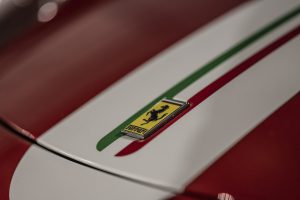 Close-up of Ferrari badge on red and white bonnet