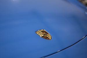The Porsche badge on a blue bonnet