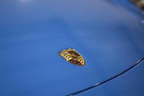 The Porsche badge on a blue bonnet