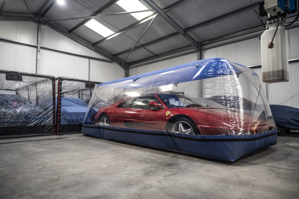 Red Ferrari w`in a garage and within a climate-controlled bubble