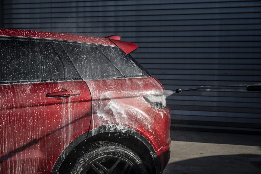 A Red Range Rover covered in soap during a wash